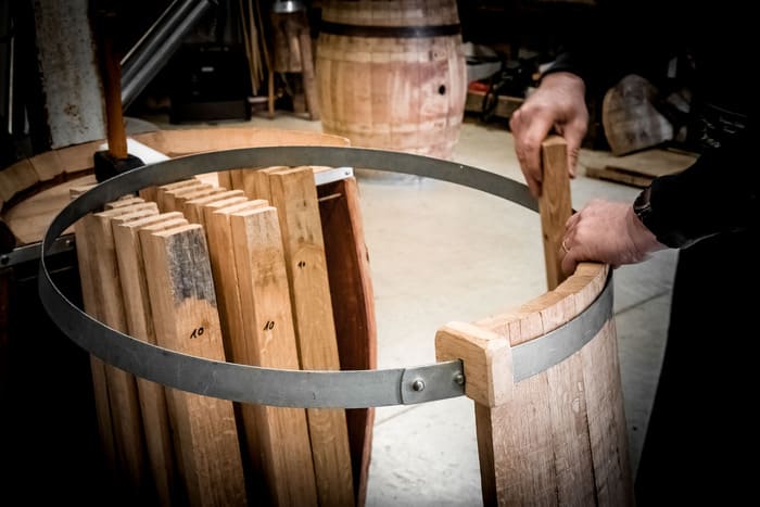 Montage d'un tonneau 228 en chêne français - mise en place des douelles sur un cercle de fer